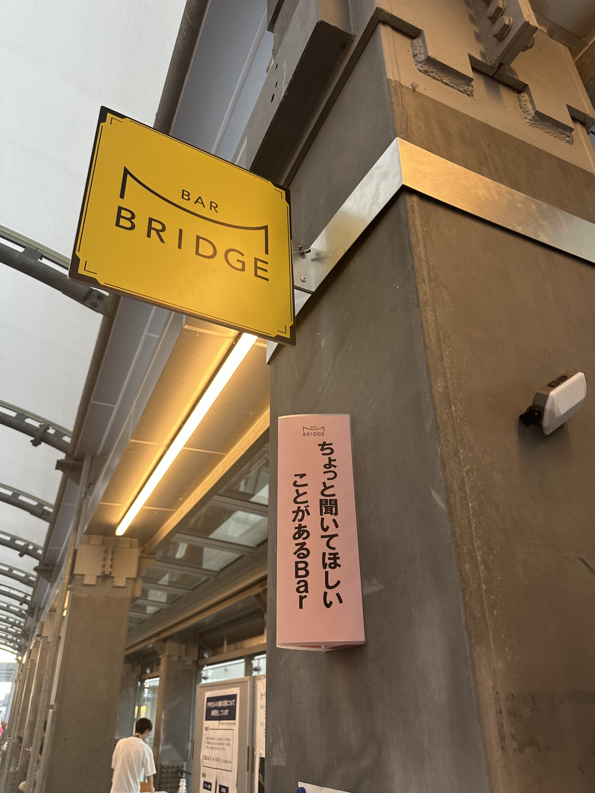 かやのさんぺい橋に掲げられたBAR BRIDGEの黄色い看板