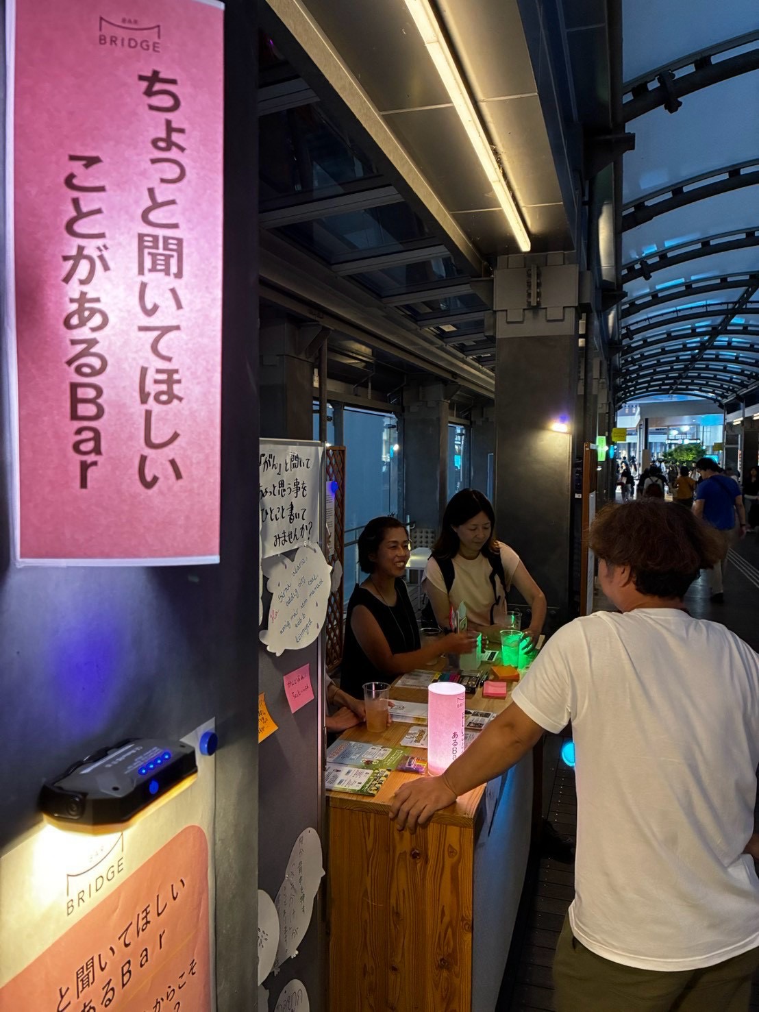 ちょっと聞いてほしいことがあるBarの案内の下で、テーブルを囲んで話す参加者